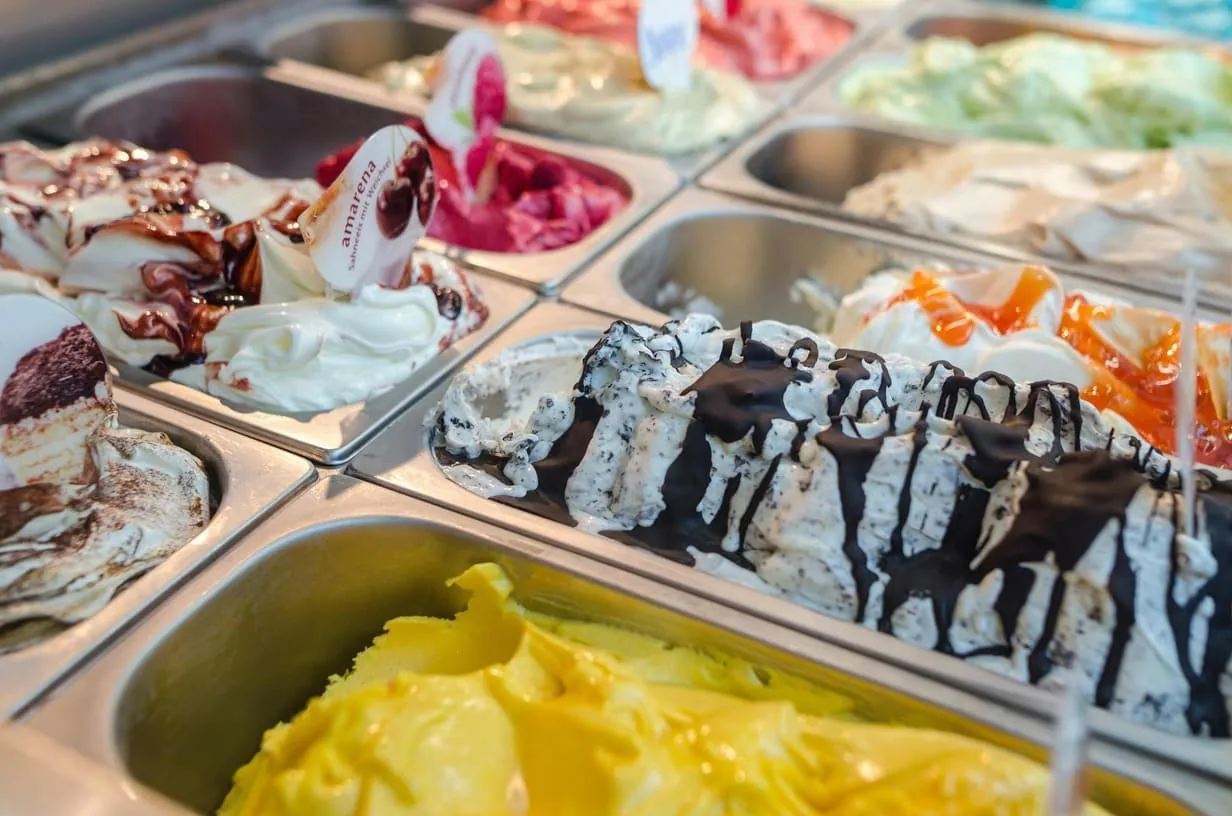 Bunte Eisauslage mit verschiedenen Sorten in der Vitrine - perfekt präsentiert für optimalen Verkauf